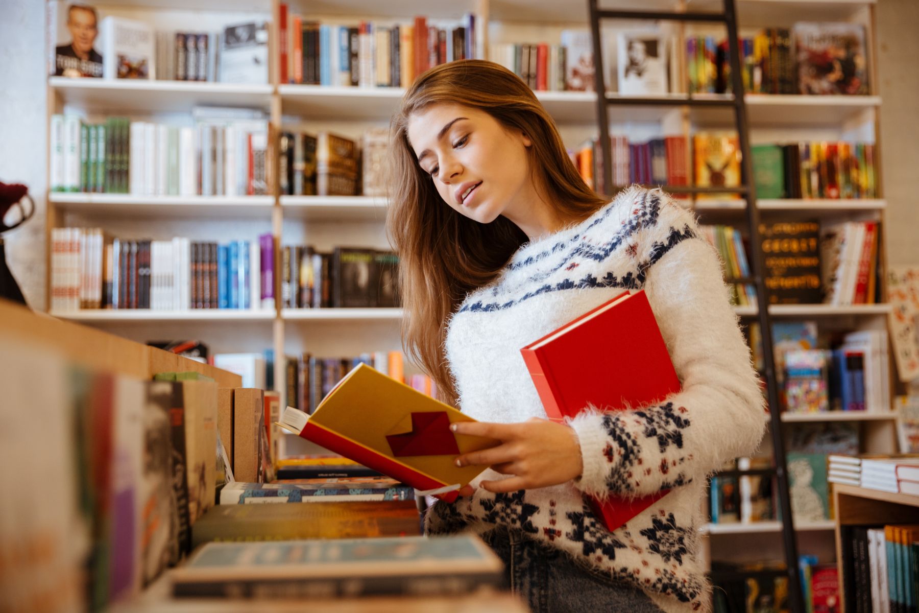 Young woman looking at books in a bookstore